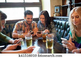 friends with smartphones and beer at bar or pub friends with smartphones and beer at bar or pub