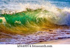 breaking ocean wave at sunset