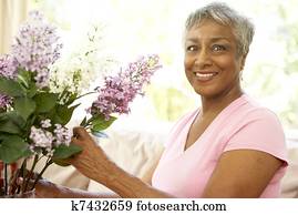 Senior Woman Flower Arranging At Home
