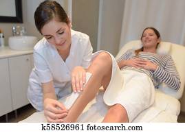 spa woman waxing her leg spa woman waxing her leg