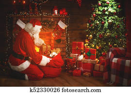 Merry Christmas! santa claus near the fireplace and tree with gifts