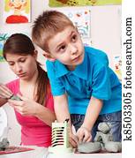 Child mould from clay with teacher. Child mould from clay with teacher.