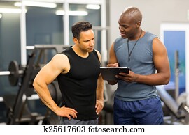 african personal trainer helping man to fill the membership form african personal trainer helping man to fill the membership form