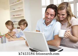 Happy young family looking and reading a laptop computer