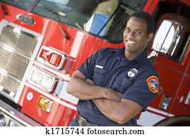Fireman standing in front of fire engine Fireman standing in front of fire engine