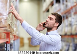 serious man calling on smartphone at warehouse serious man calling on smartphone at warehouse