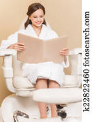 Young woman receiving pedicure in hairdressing salon. Woman with hair color samples sits in hairdress salon