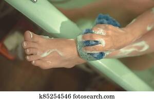 Women's foots in the bathroom. The girl bathes. Photo is out of focus. Women's foots in the bathroom. The girl bathes. Photo is out of focus.
