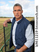 Farmer stood by tractor