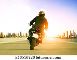 rear view of man riding motorcycle on urban traffic road for people leisure traveling theme rear view of man riding motorcycle on urban traffic road for people leisure traveling theme
