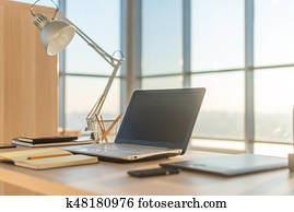 Side view picture of studio workplace with blank notebook, laptop. Comfortable work table, home office.