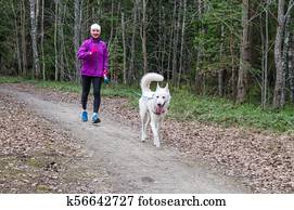 Woman with a dog on a run in the park Woman with a dog on a run in the park