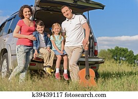 Smiling happy family and their car