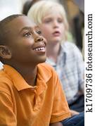 Students in class sitting on floor paying attention (selective focus)