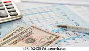 Dollar bills on documents with a calculator