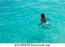Teenage Cape verdean boy swimming on the turquoise  water of Santa Maria beach in Sal Cape Verde - Cabo Verde