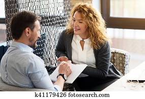 Woman talking to man and he is taking notes