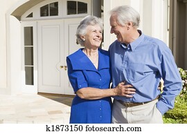 Senior couple standing outside house Senior couple standing outside house