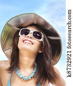 Girl in bikini and sunglasses on beach.