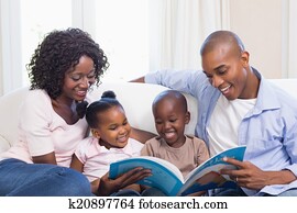 Happy family on the couch reading storybook Happy family on the couch reading storybook
