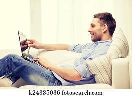 smiling man working with laptop at home