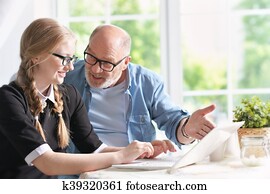 grandfather and granddaughter doing homework grandfather and granddaughter doing homework
