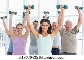 Class exercising with dumbbells in gym Class exercising with dumbbells in gym