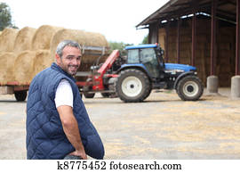 Farmer stood by hay barn Farmer stood by hay barn