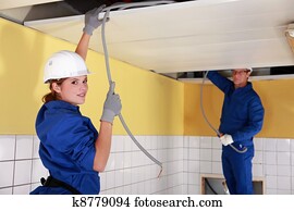 Young female electrician with mentor Young female electrician with mentor