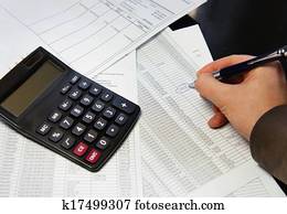 Office table with calculator, pen and accounting document