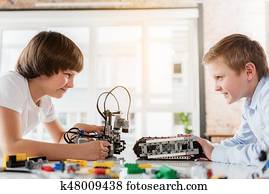 Cheerful male children playing with robotics Cheerful male children playing with robotics