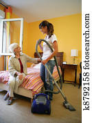 Cleaner vacuuming bedroom Cleaner vacuuming bedroom