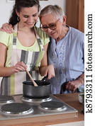 Granddaughter cooking for her grandmother