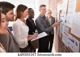 Manager Analyzing The Graph With His Colleague Manager Analyzing The Graph With His Colleague