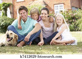 Family Sitting In Garden Together
