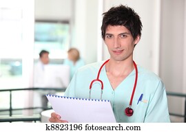 Young hospital doctor checking notes