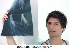 Young male medic examining Xrays of hands