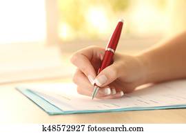 Woman hand filling form on a table