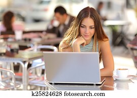 Woman watching media in a laptop in a coffee shop Woman watching media in a laptop in a coffee shop