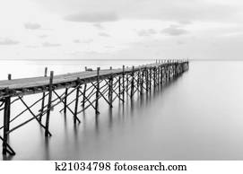Black and white photography of a beach wooden pier Black and white photography of a beach wooden pier
