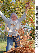 grandmother playing with a heap of dead leaves