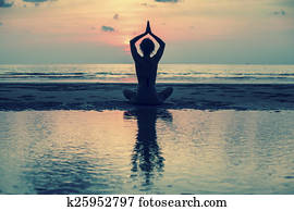 Yoga, silhouette young woman on the beach at sunset, harmony of health.