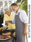 Couple Cooking On A Barbeque Couple Cooking On A Barbeque