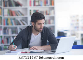 estudiante, en, biblioteca de la escuela, usar la computadora portátil, para, investigación