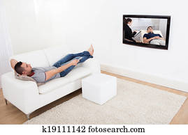 hombre, en, sofá, mirando tele