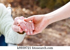 Senior Lady Holding Hands with Young Caretaker Senior Lady Holding Hands with Young Caretaker