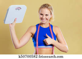 femme sportive heureuse avec échelle de perte de poids femme sportive heureuse avec échelle de perte de poids