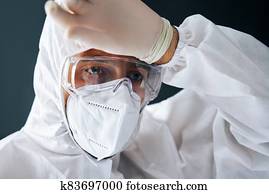 Tired doctor in PPE suit wipe the sweat after hard working day Tired doctor in PPE suit wipe the sweat after hard working day