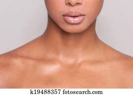Beautiful lips. Cropped image of beautiful young Afro-American shirtless woman standing while isolated on gray background