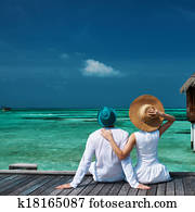 Couple on a beach jetty at Maldives